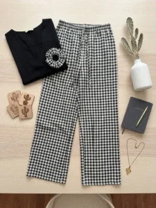 Pantalón de cuadros vichy con camiseta negra sobre madera