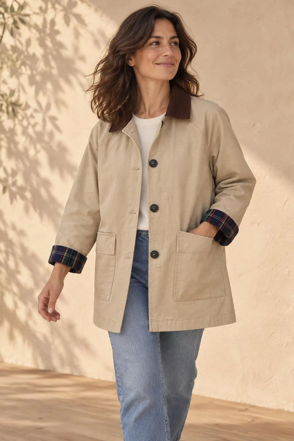 Chaqueta beige con los puños remangados mostrando el forro de cuadros